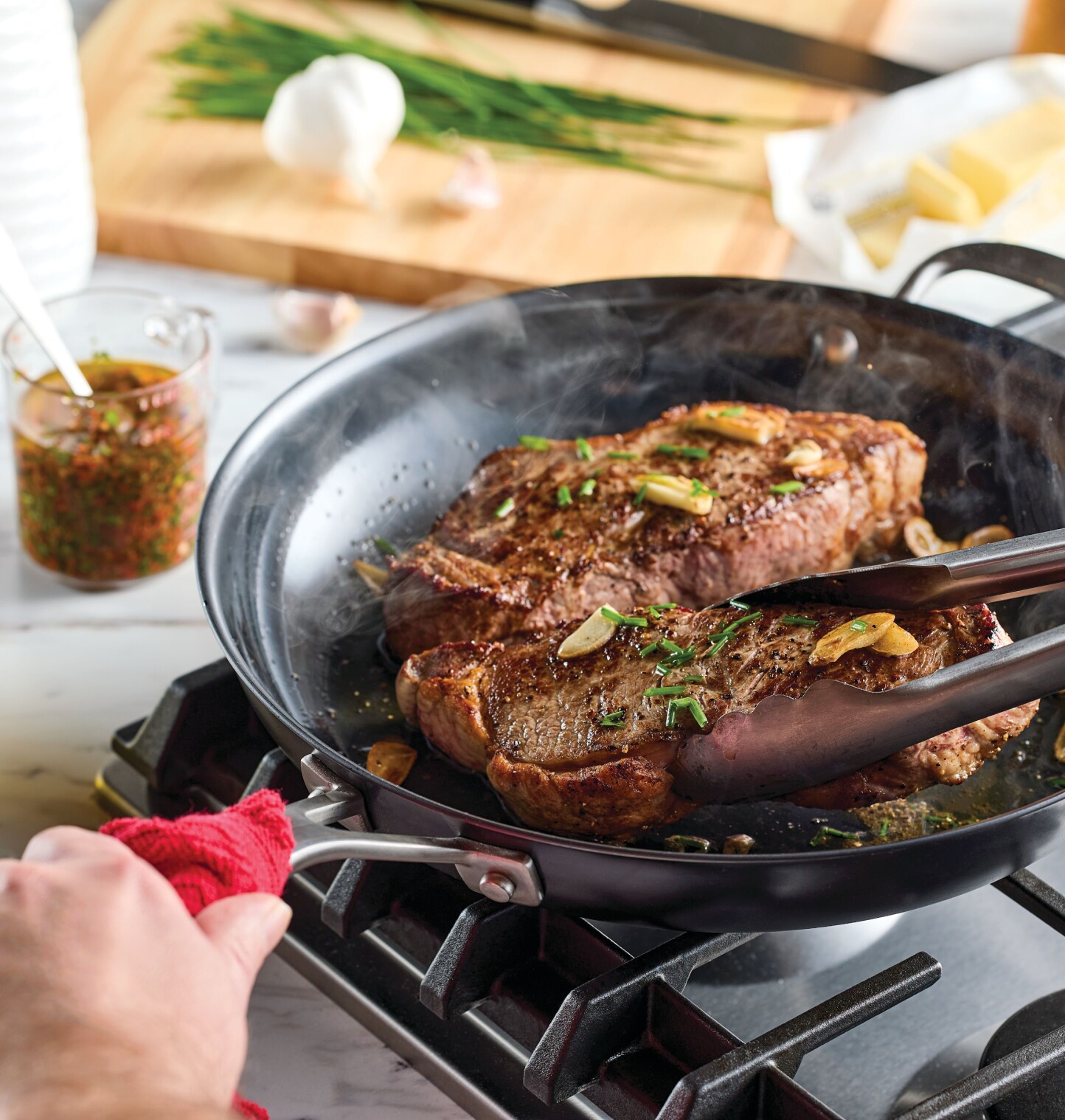 A person cooking with KitchenAid® Nitro Carbon Steel cookware.