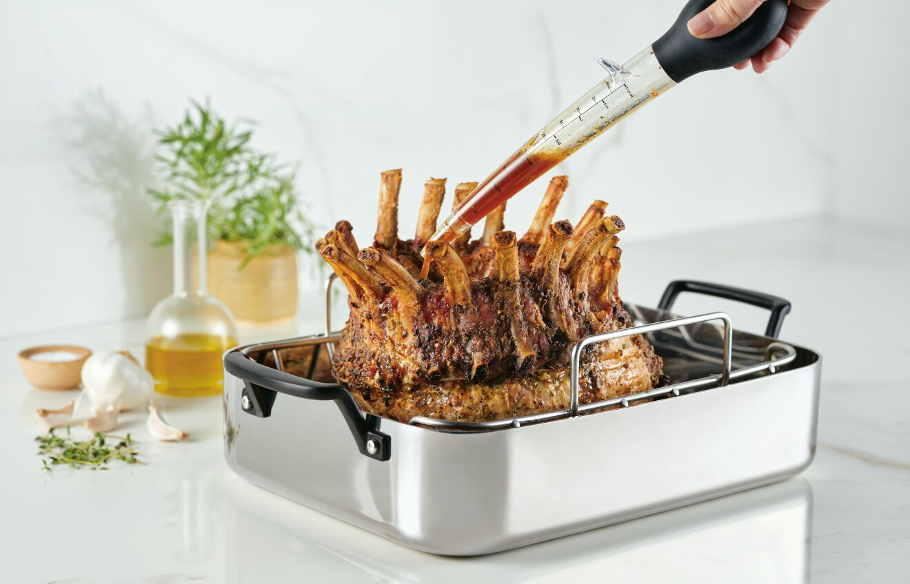 Person basting meal in KitchenAid Roasting Pan.
