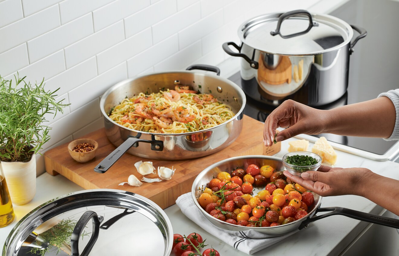 Person preparing a meal with KitchenAid® Stainless Steel Cookware