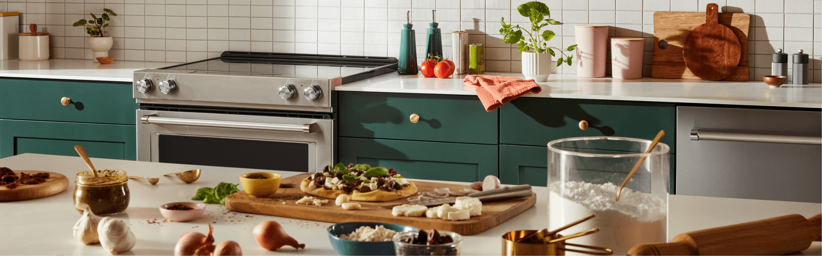 A bright, modern kitchen filled with a suite of KitchenAid® appliances and dishware and ingredients scattered across the counters. 