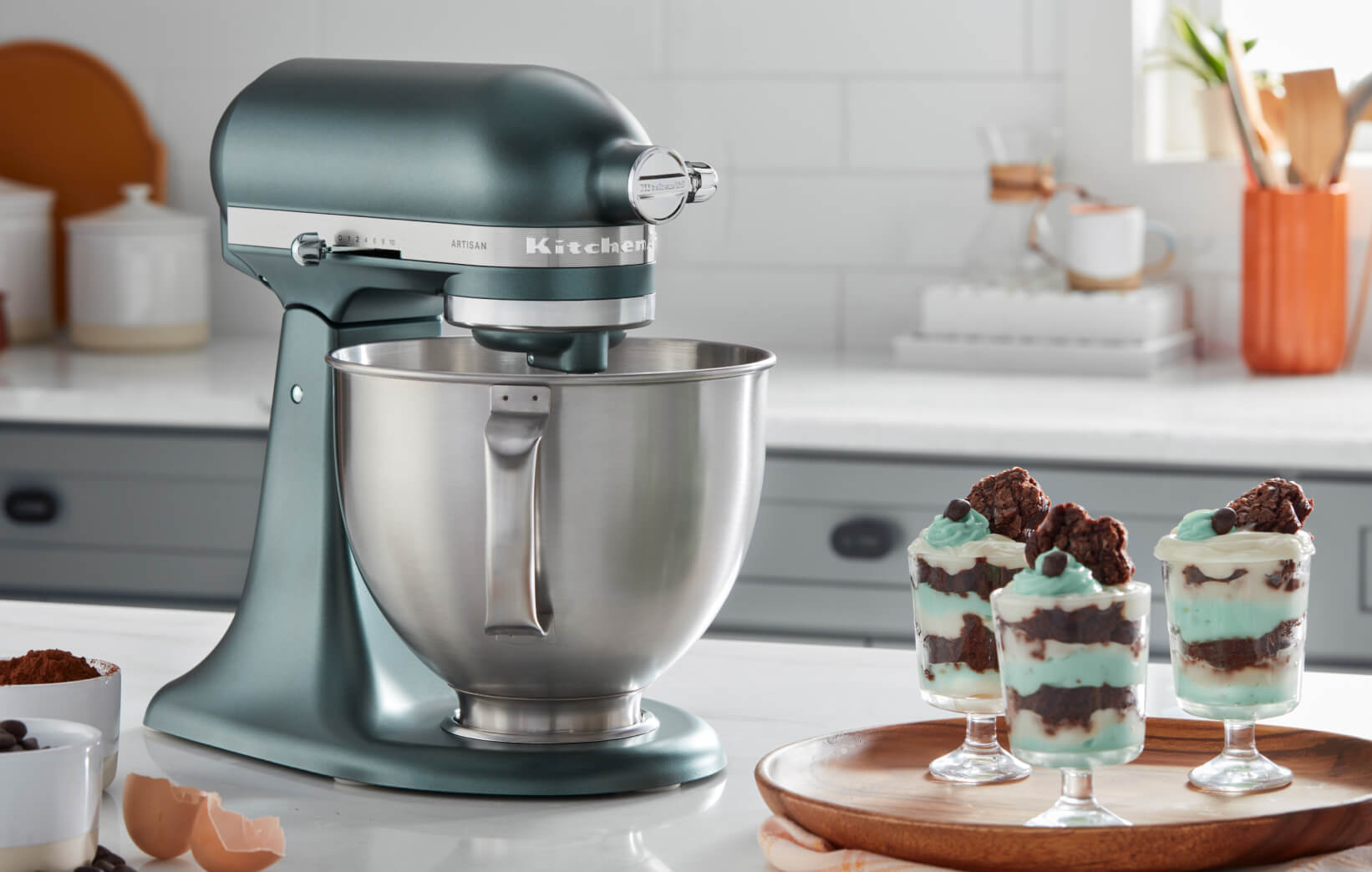A Juniper Tilt-Head Stand Mixer on a countertop near three parfaits.