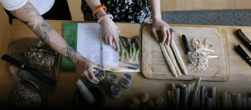 Two people following a recipe featuring asparagus.