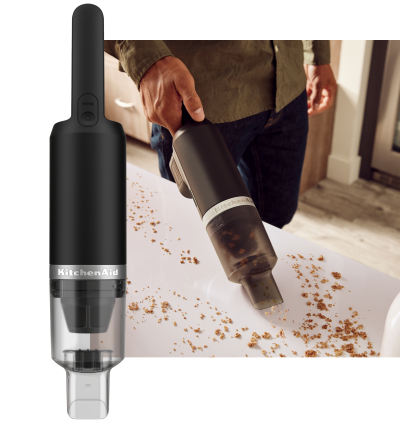 KitchenAid Go™ Cordless Kitchen Vacuum and a person using the vacuum to pick up crumbs on a countertop.