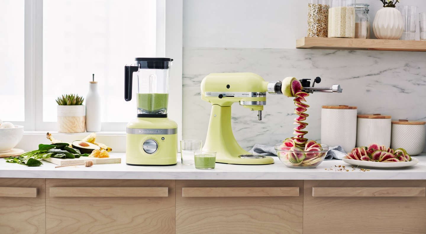 Green KitchenAid® stand mixer with spiralizer attachment, spiralizing fruit next to green KitchenAid® blender Green KitchenAid® stand mixer with spiralizer attachment, spiralizing fruit next to green KitchenAid® blender