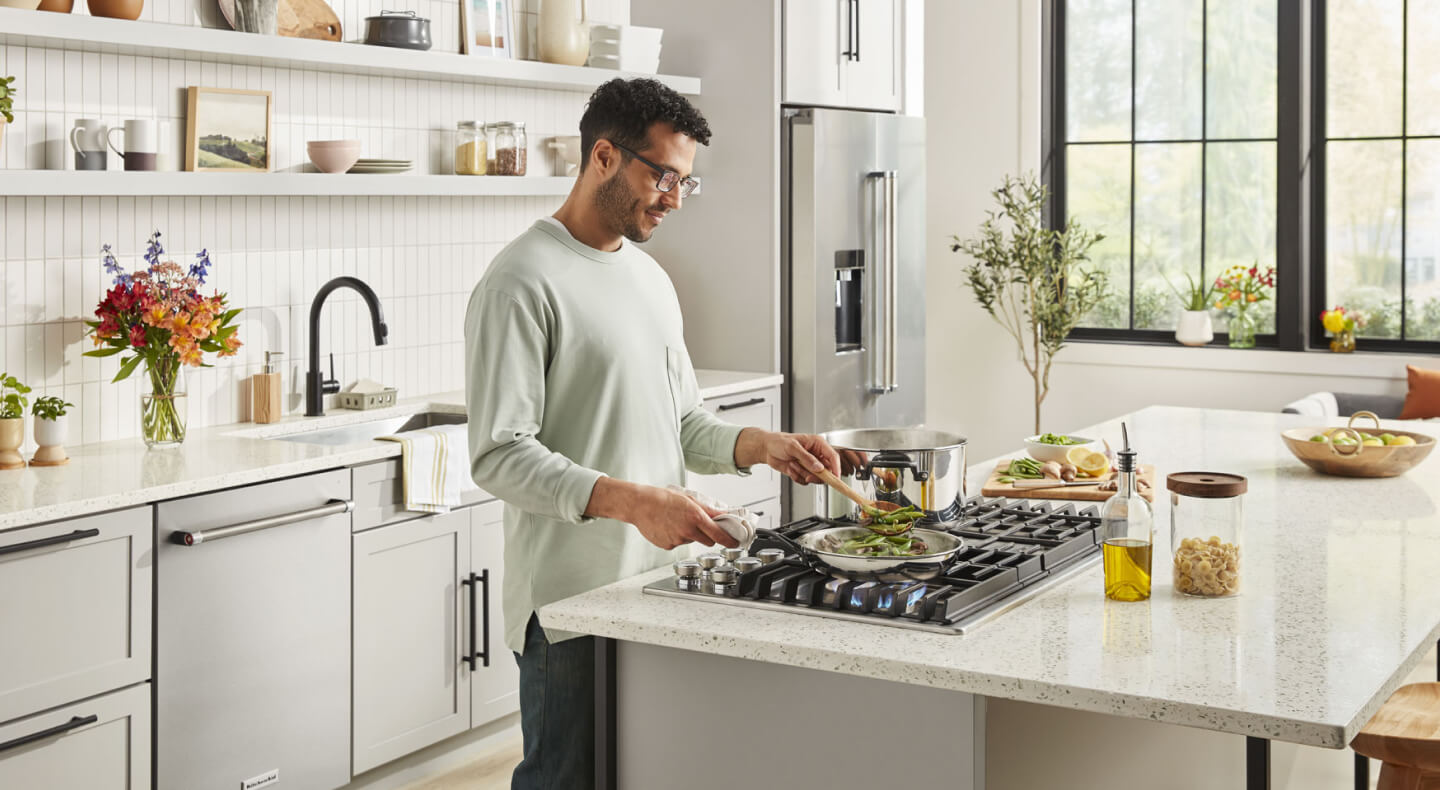 Person cooking on a gas cooktop  Person cooking on a gas cooktop