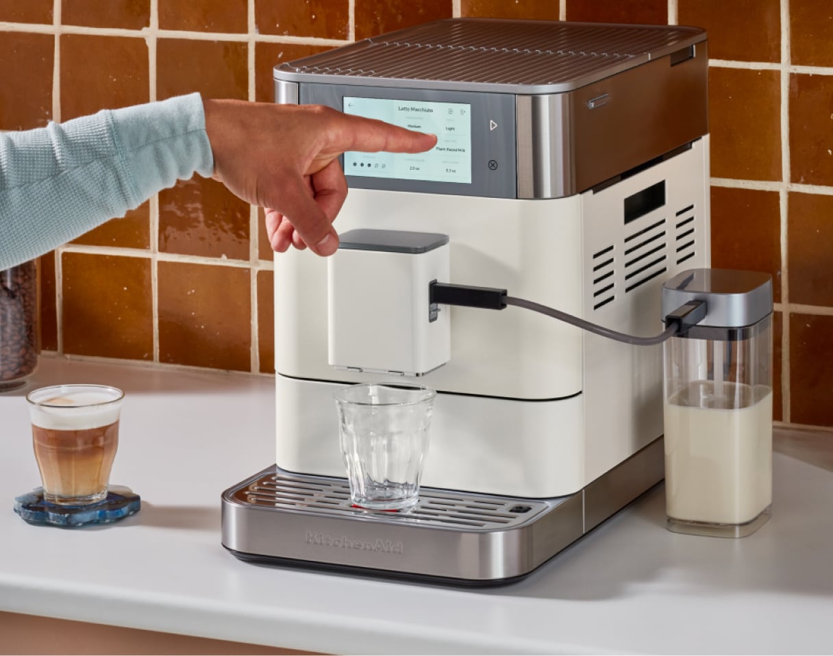 A person making espresso with a KitchenAid® Espresso Machine.
