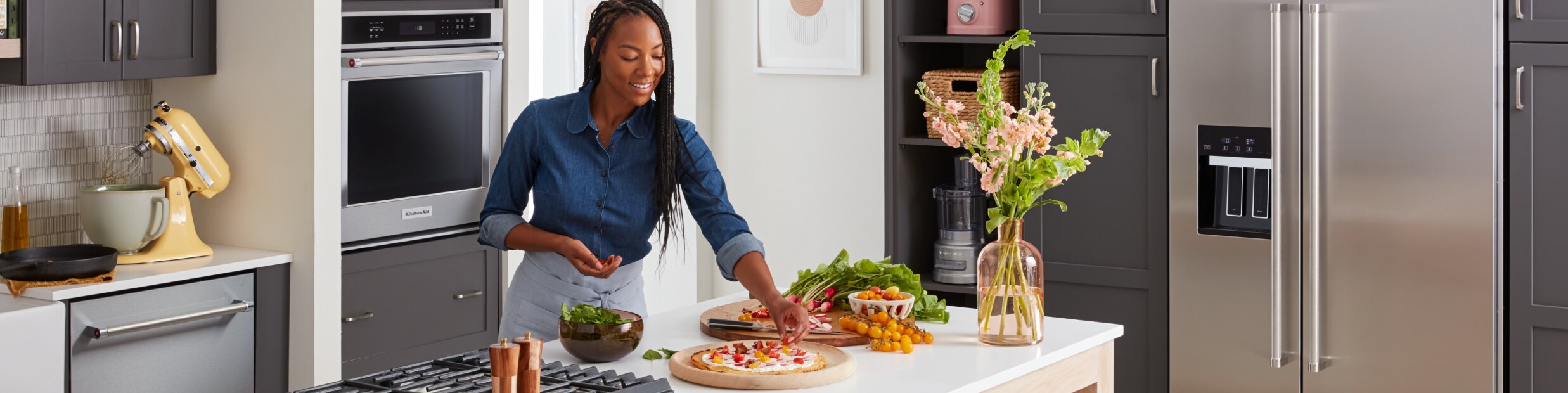 A person cooking on a KitchenAid® countertop.