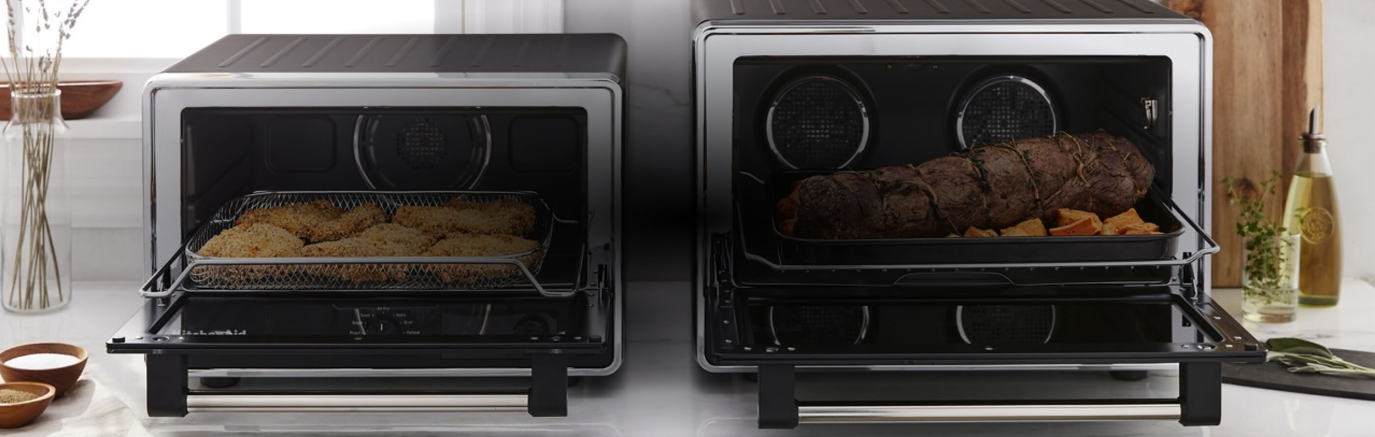 Two KitchenAid® Countertop Ovens resting on a kitchen counter.