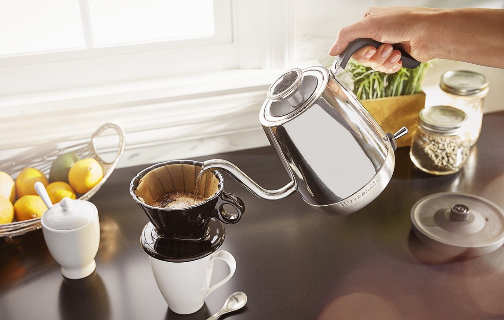 A person pouring water over a coffee filter.