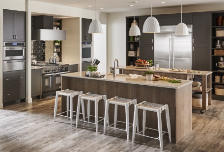 A modern kitchen with dark cabinetry and KitchenAid stainless steel appliances