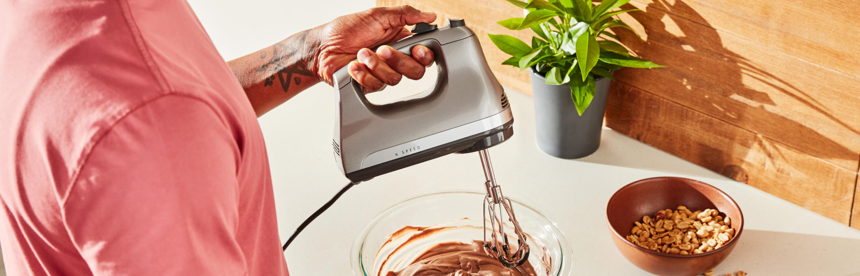 A person using a 6-Speed Hand Mixer.