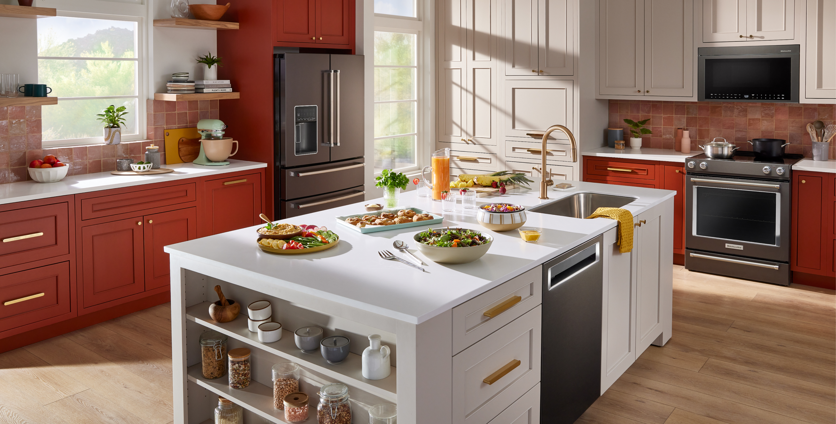 A kitchen with red cabinets and KitchenAid appliances.