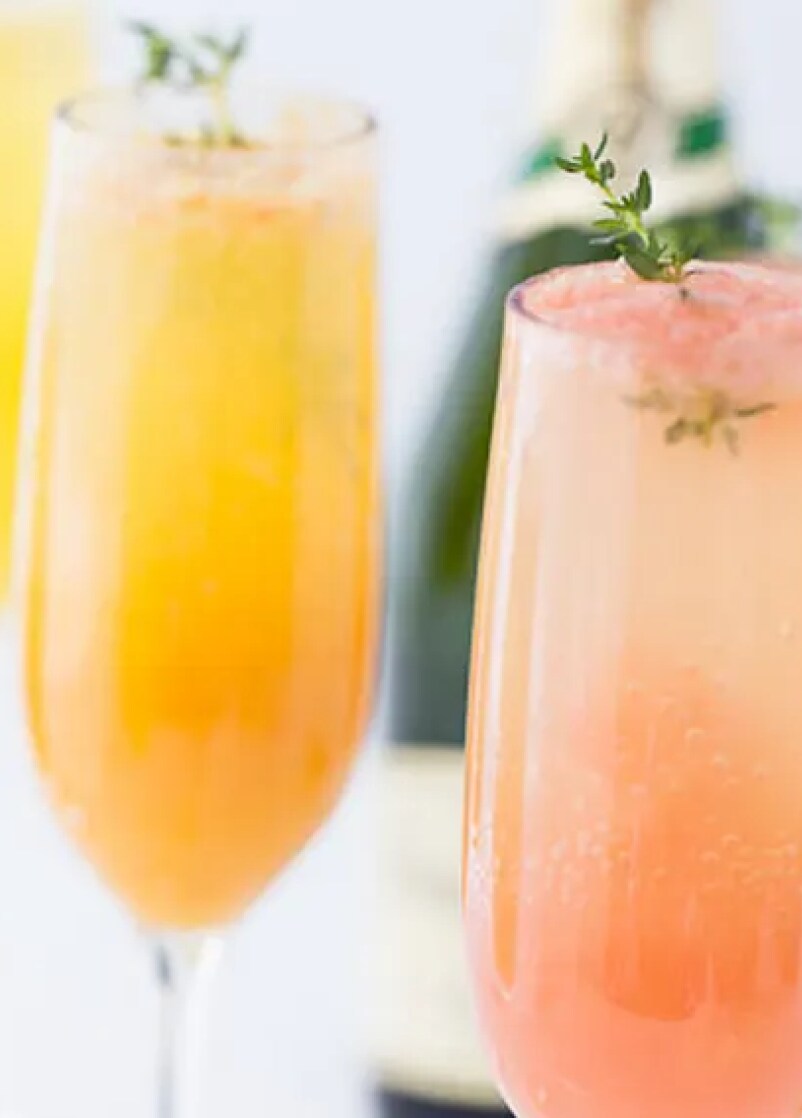 Closeup of two cocktails in champagne flutes.