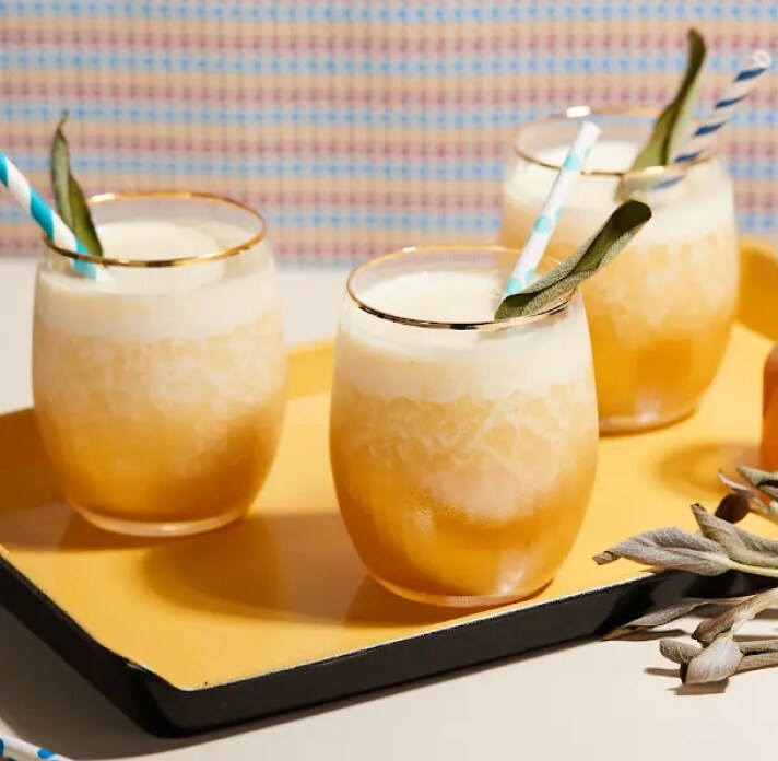 Three cocktails in gold-rimmed glasses.