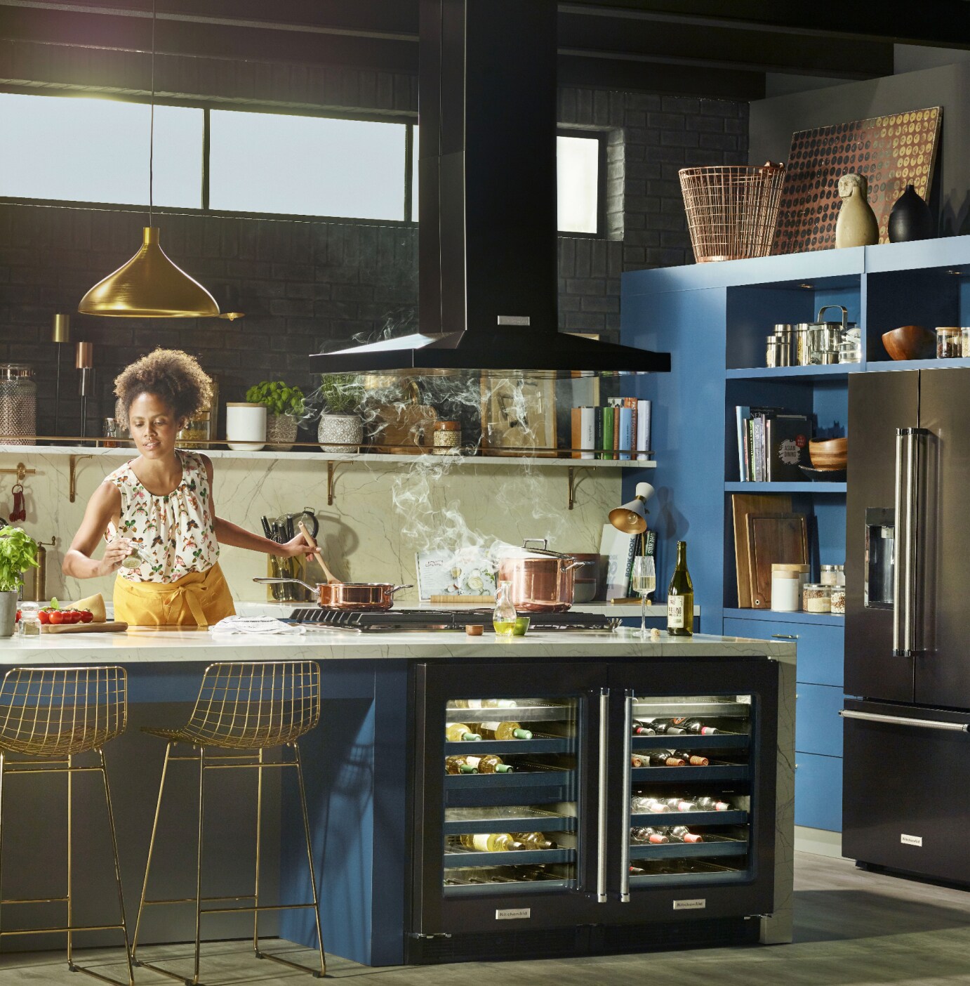 Young female Maker in a stylish, updated kitchen cooking over a pot of steaming liquid.