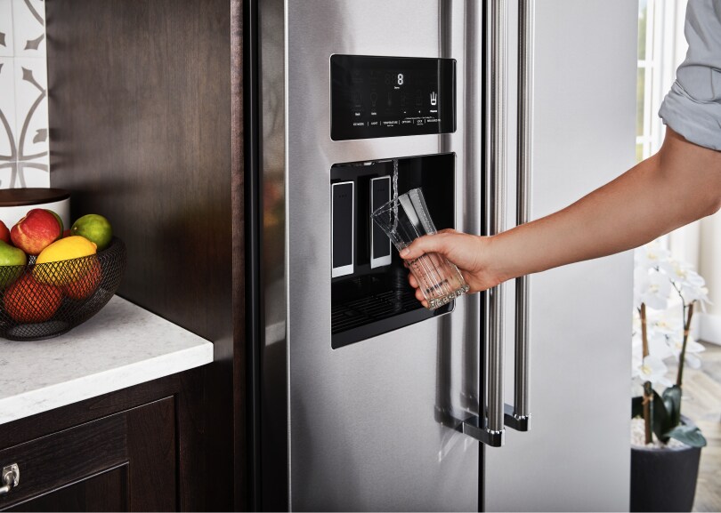 Filling a glass from a KitchenAid refrigerator water dispenser.