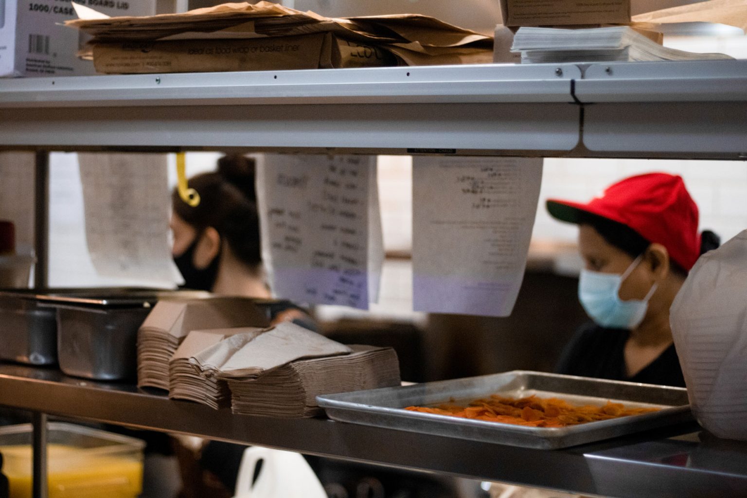 Kitchen order tickets strewn about for workers to fulfill.