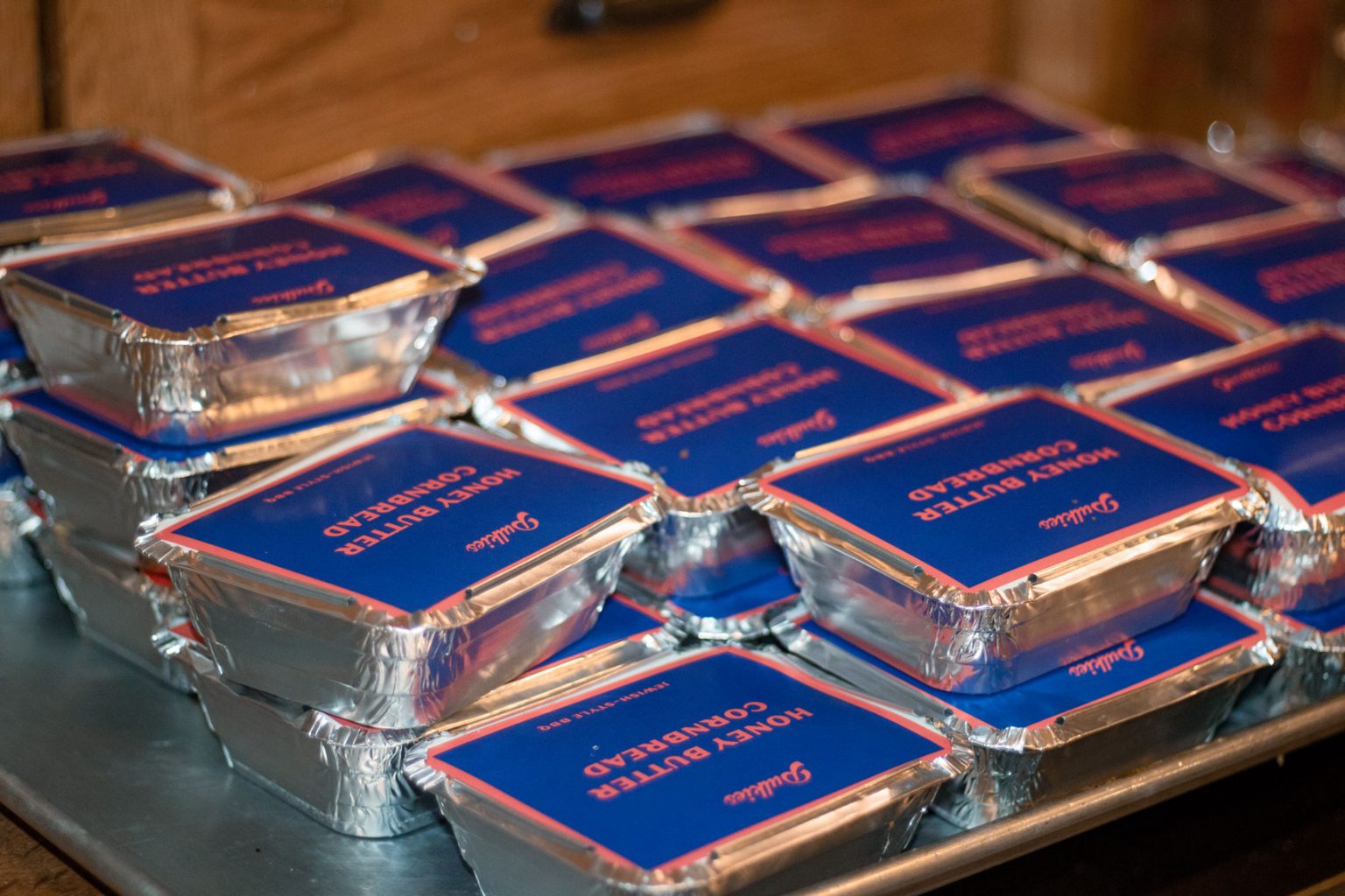 A series of sealed foil containers filled with honey butter cornbread.