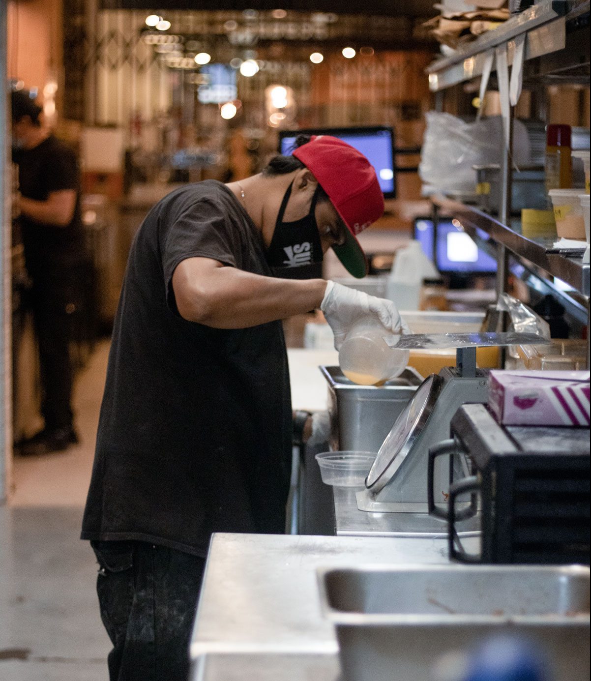 A person diligently prepping in in the Pulkies kitchen.