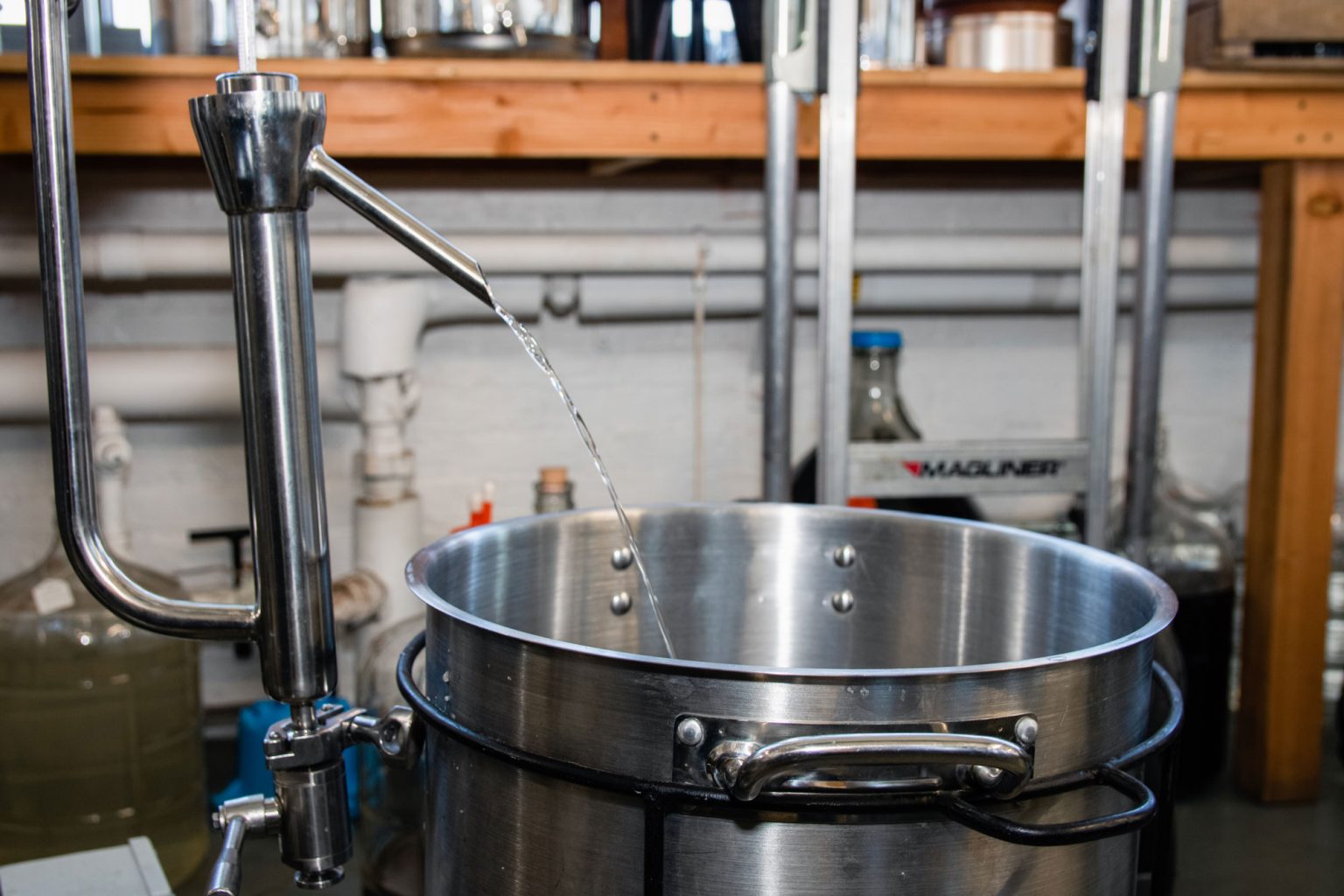 Distilled liquor pouring into a pot.