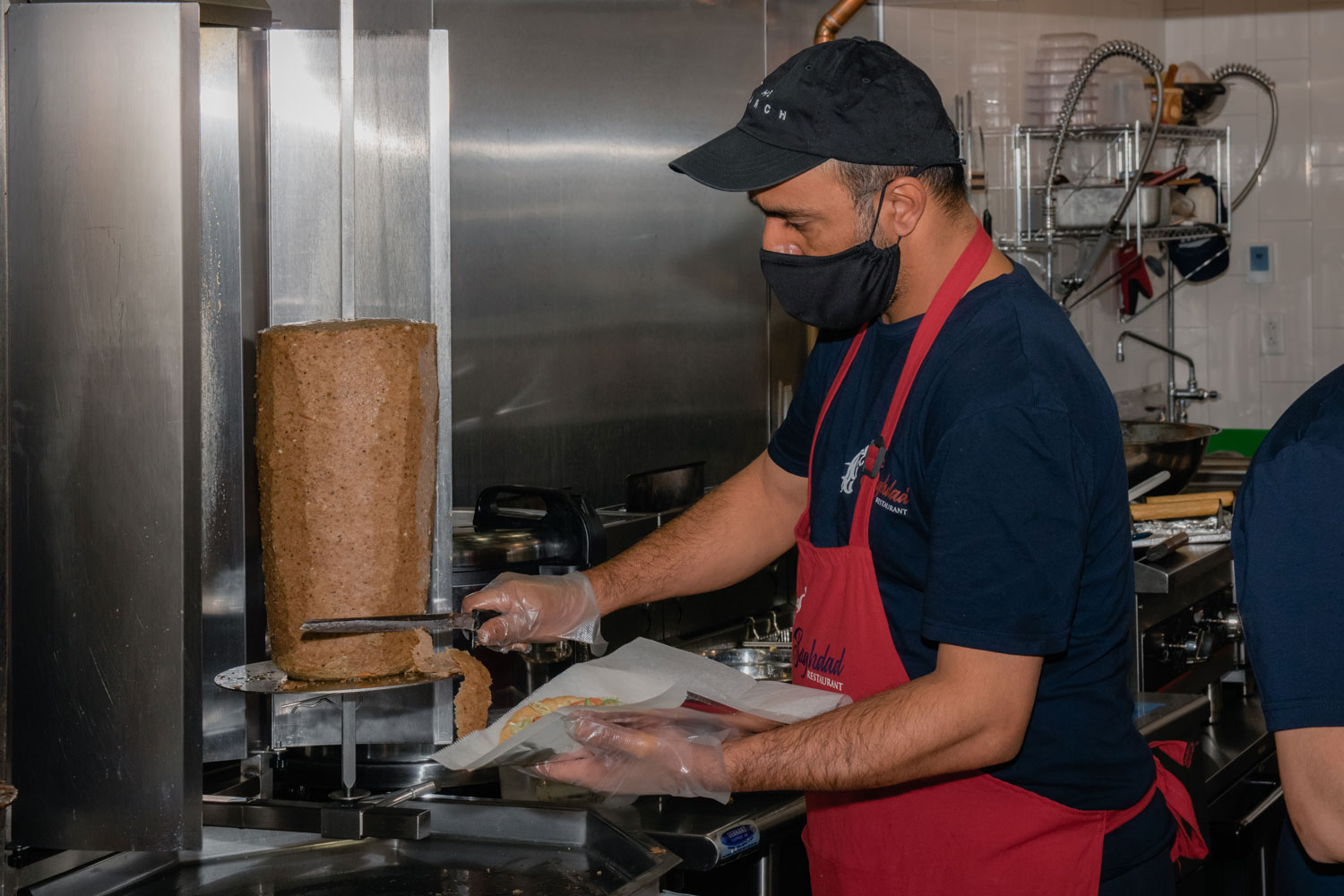 Firas trimming meat for a gyro.