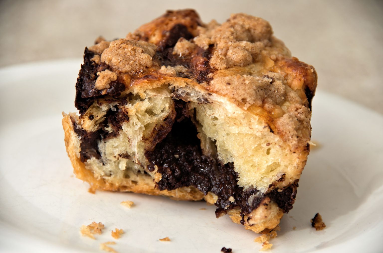 A half-eaten slice of chocolate babka bread on a white plate.