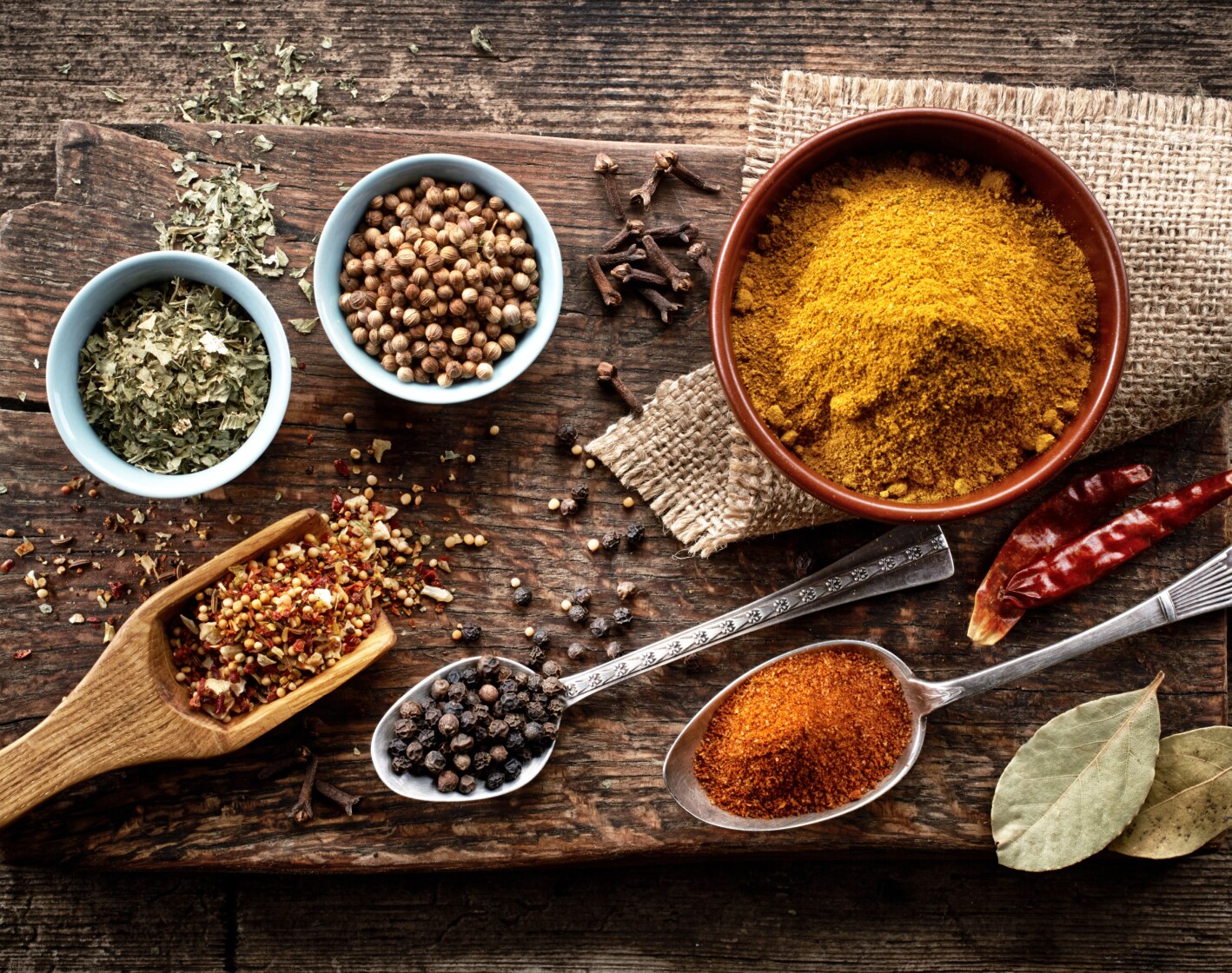 Small bowls and spoons filled with dried spices