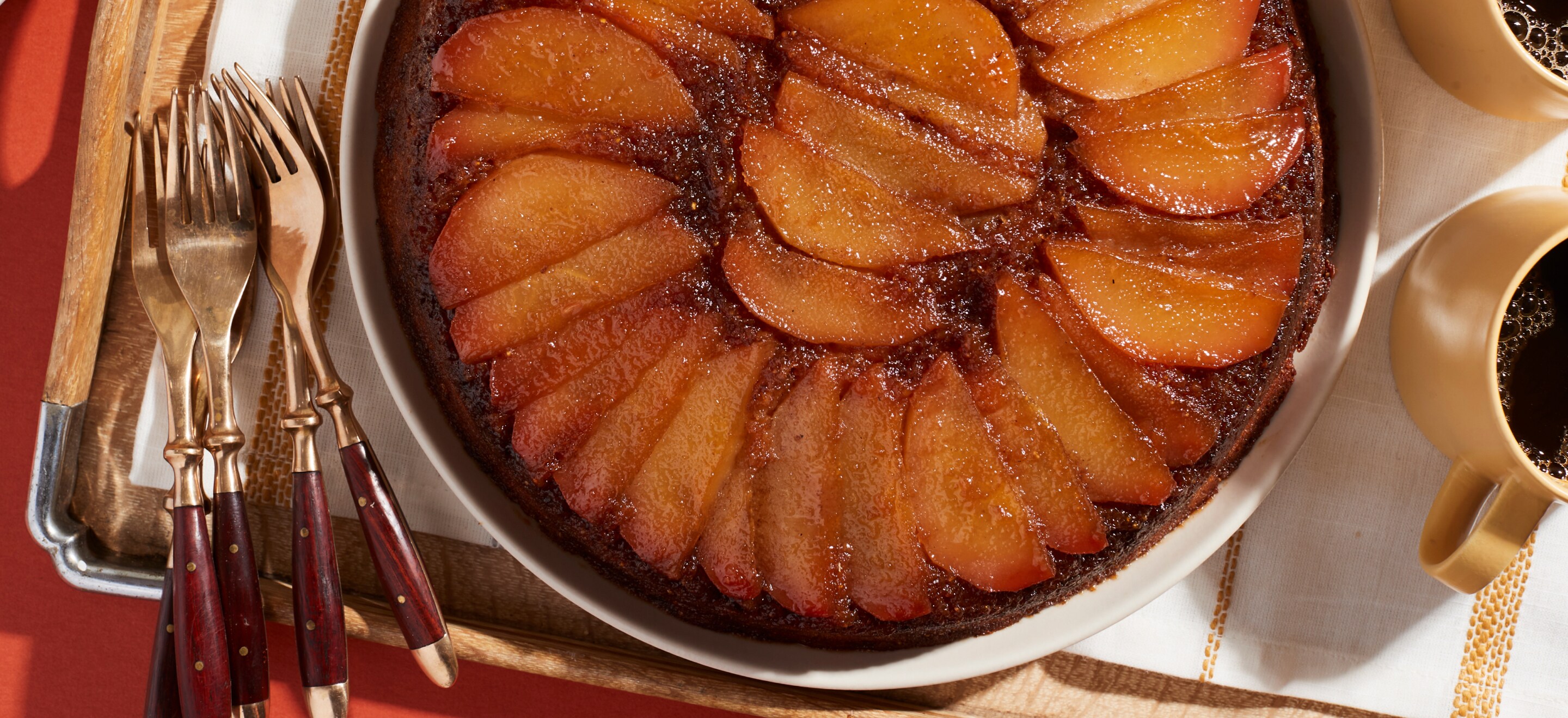 Baked spiced pear cake next to cups of coffee