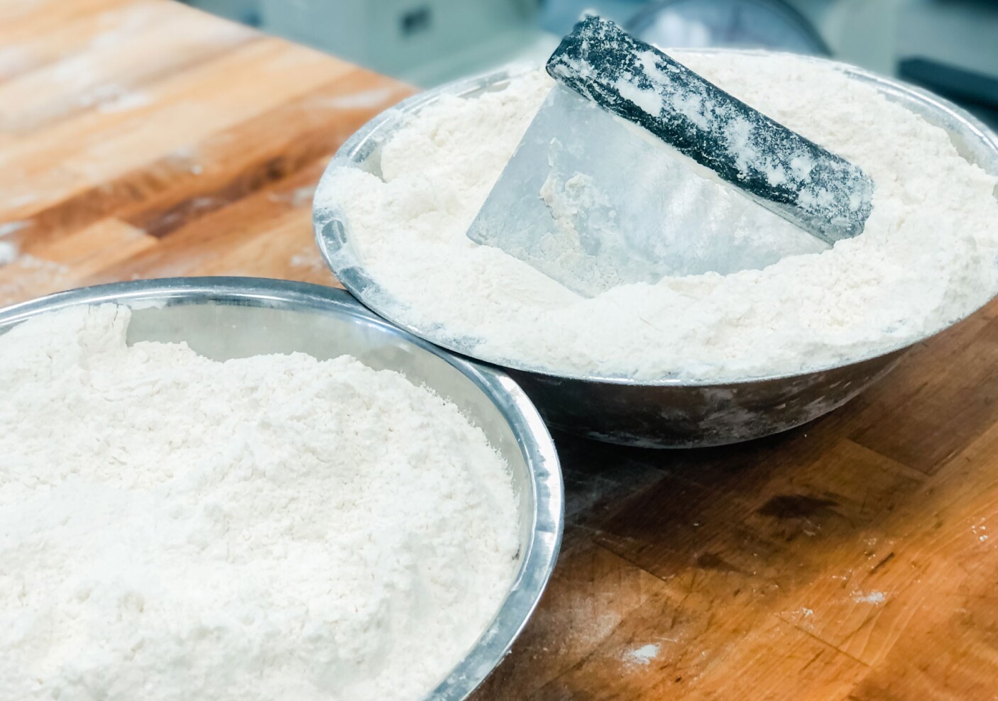 Two metal bowls filled with flour.