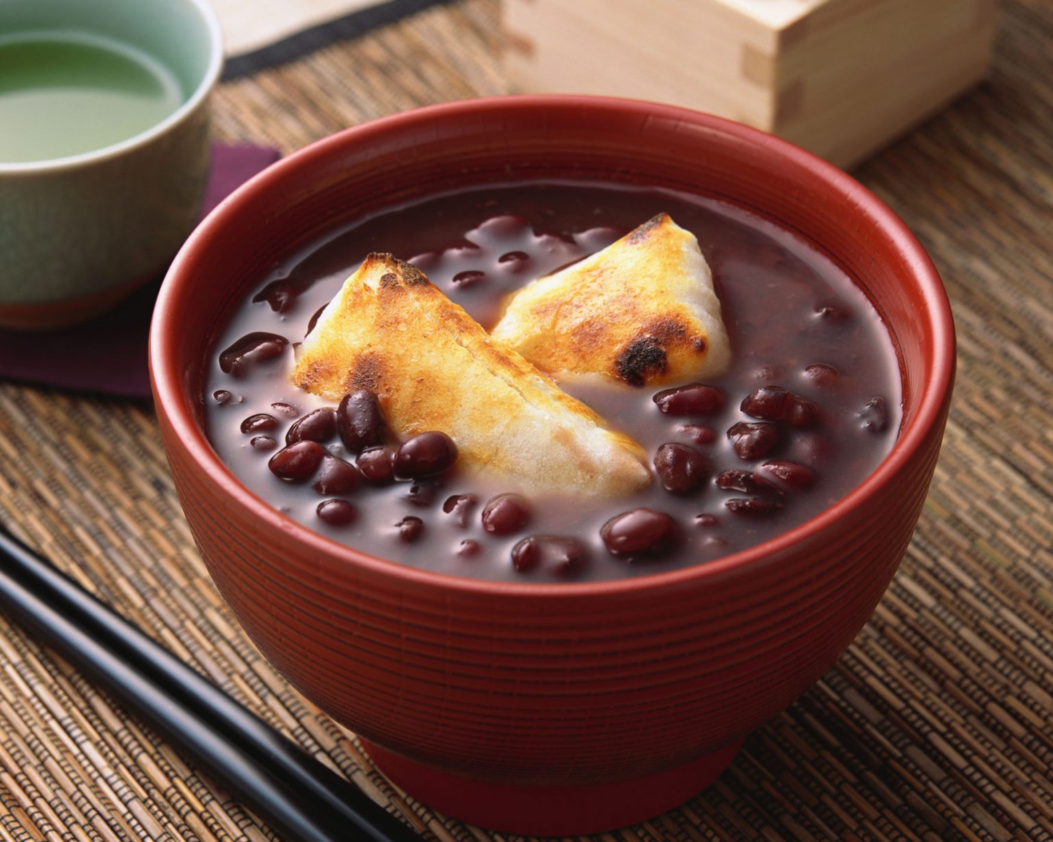 A sweet red bean soup in a dark orange bowl.
