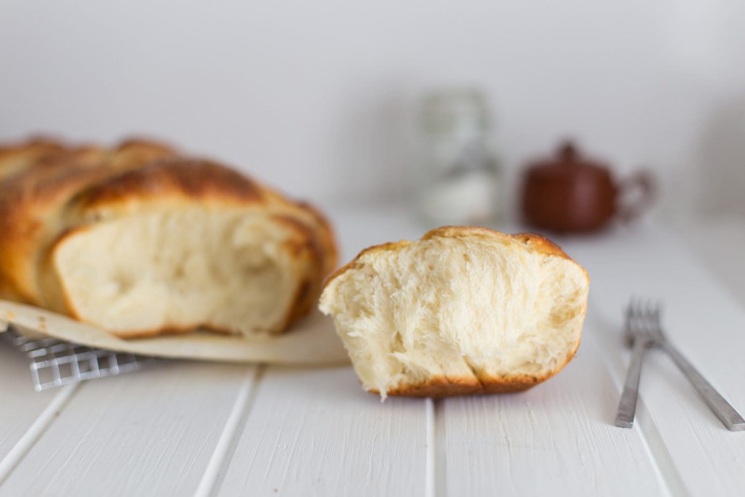 Pulled apart brioche bread on a white table.