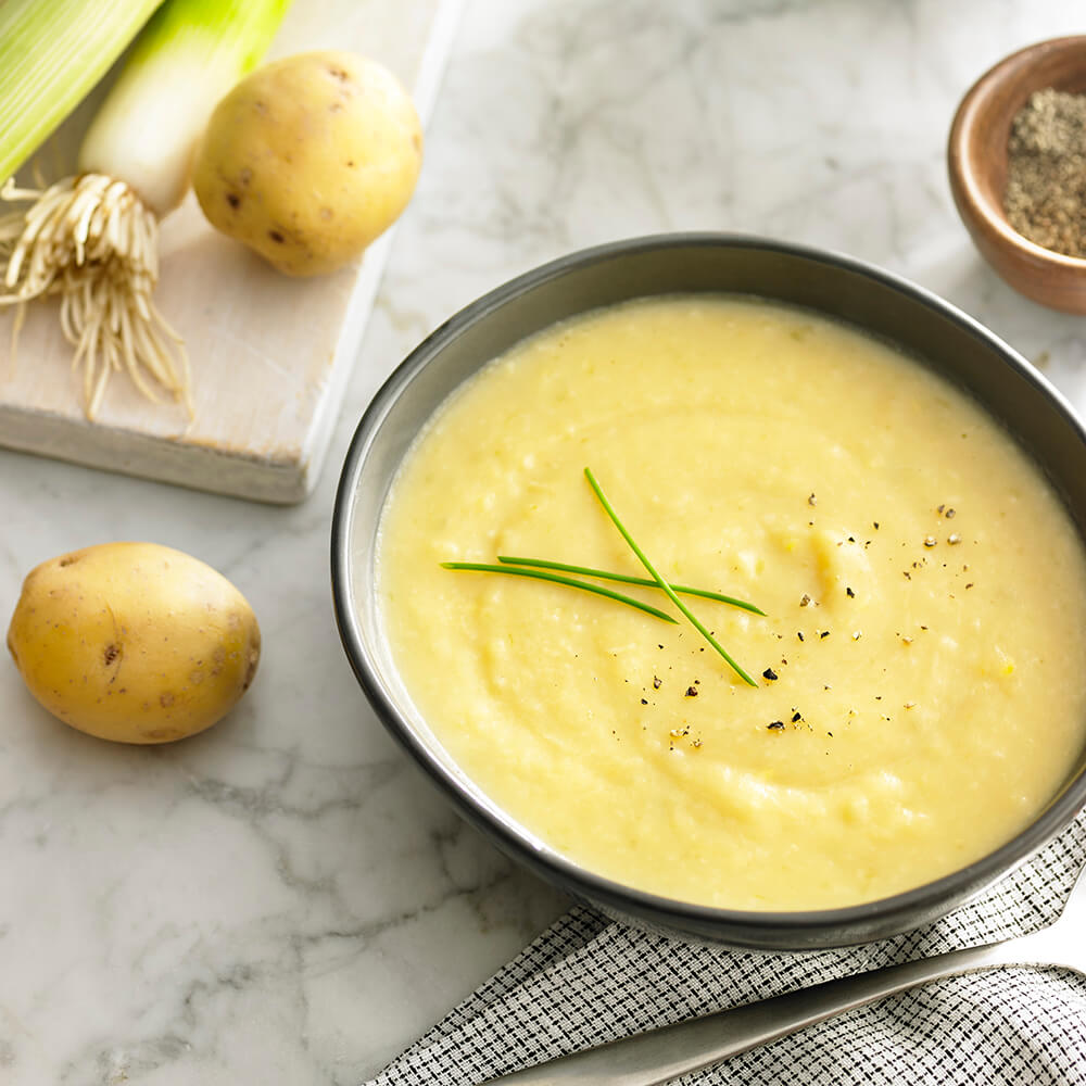 A creamy bowl of polenta garnished with fresh herbs and seasonings.