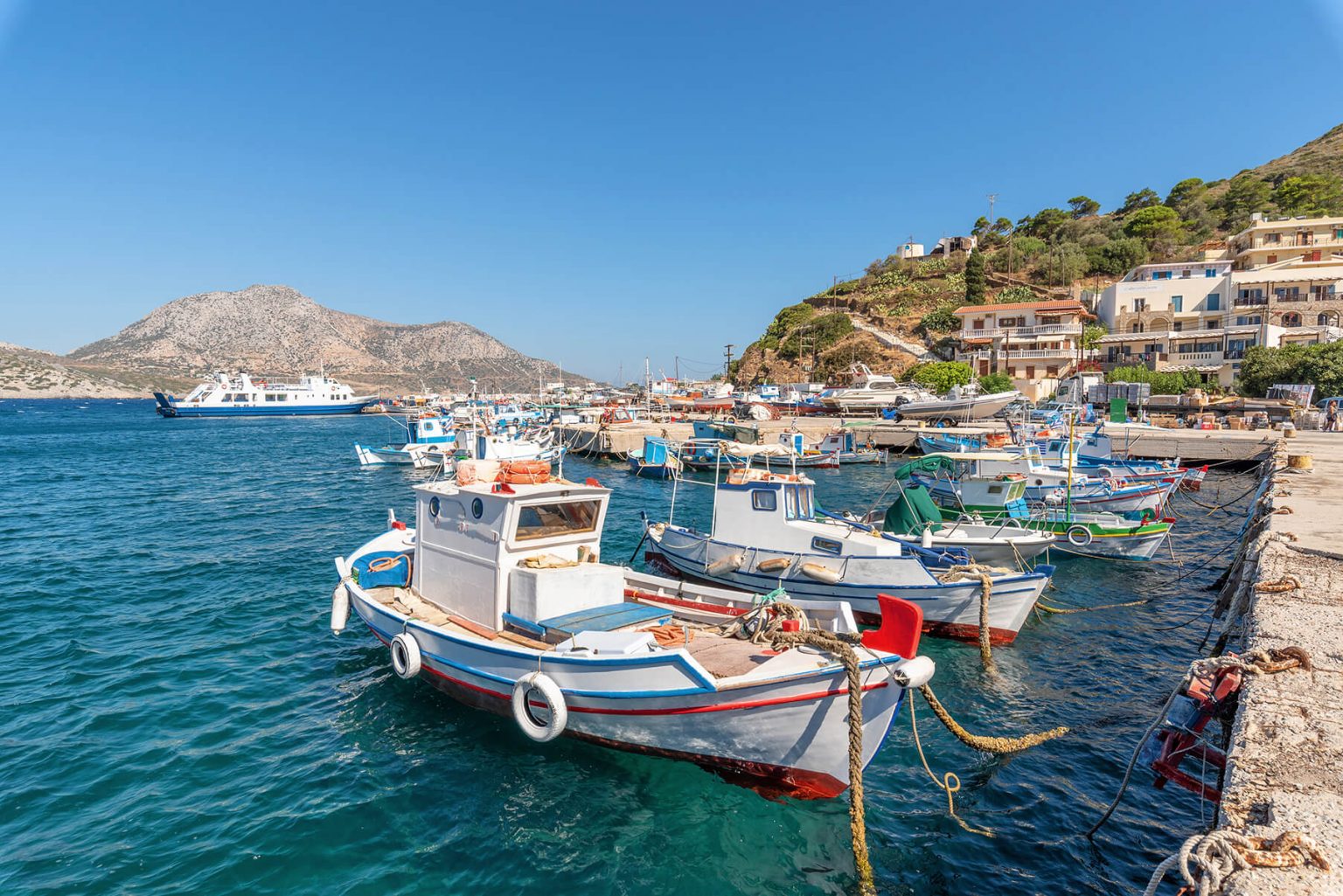Docked, empty fishing boats floating on brilliantly blue water