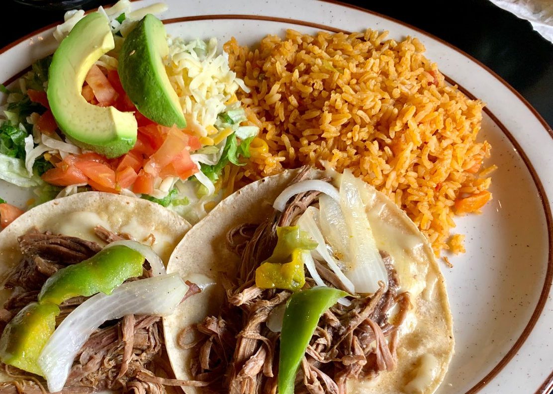 A full plate of shredded meat tacos, Mexican rice and a small salad.