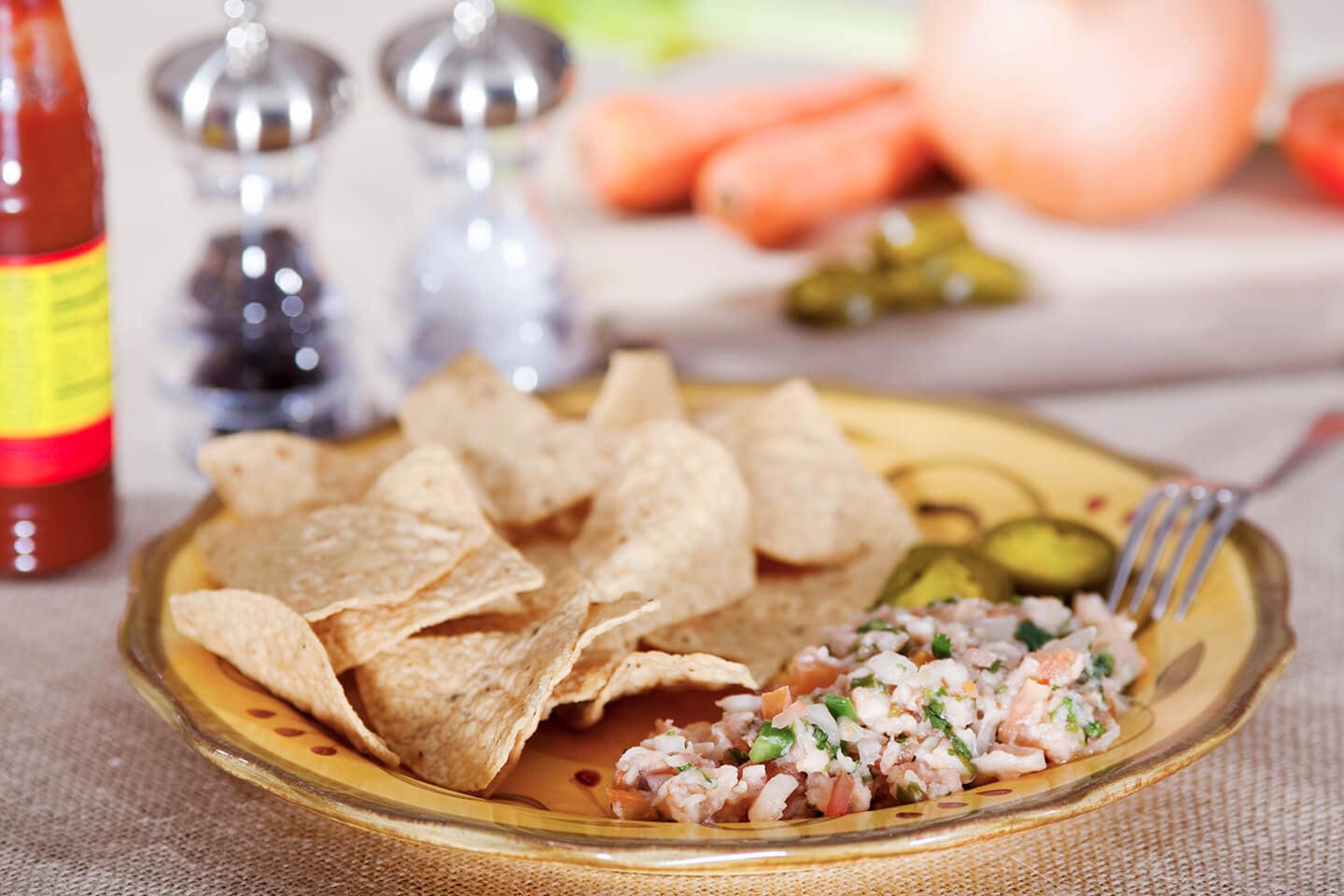 A plate filled with crisp tortilla chips and freshly made ceviche.
