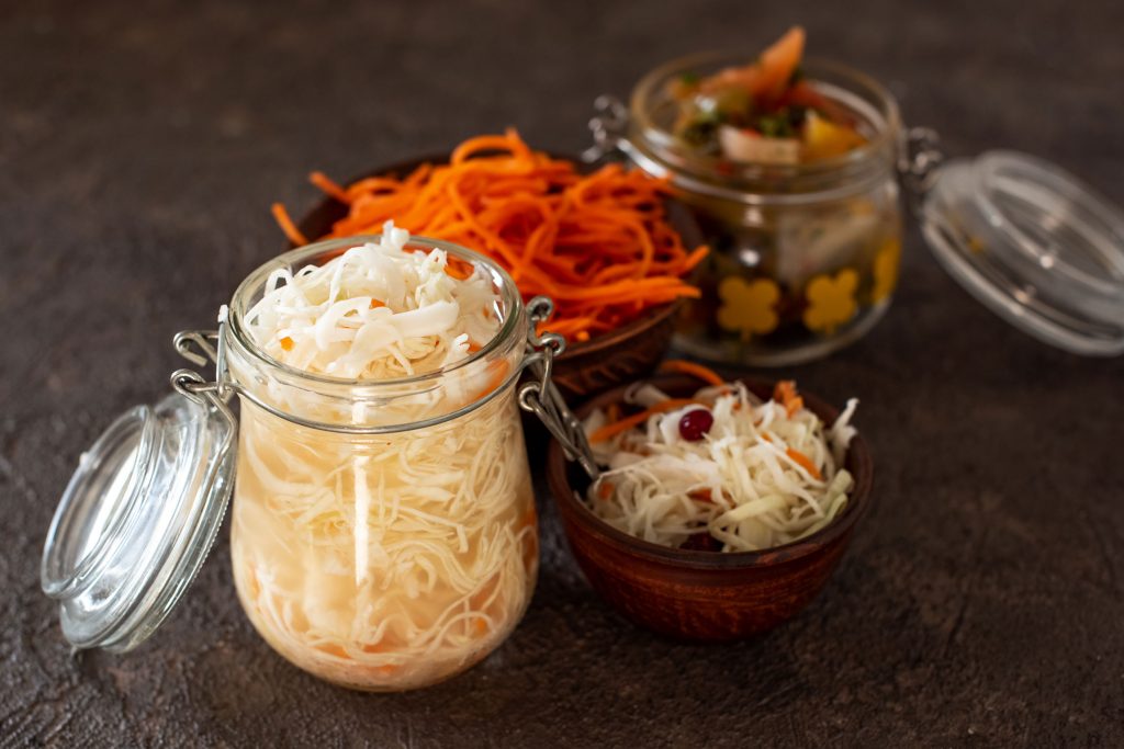 A large, open glass jar filled to the rim with sauerkraut.