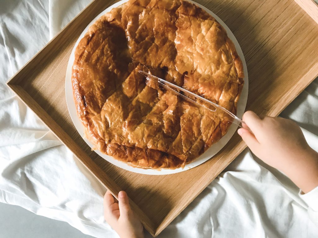 A person gently slicing the galette des rois.
