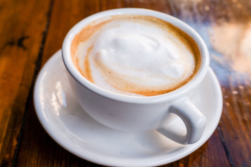A chai tea latte in a tea cup.