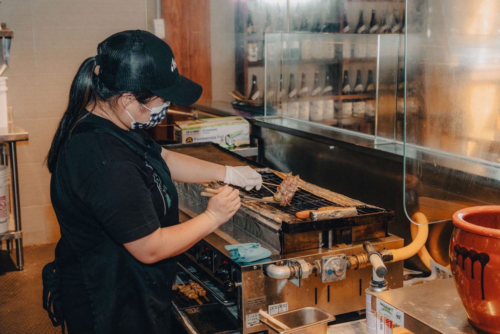 A person cooking over an indoor grill.