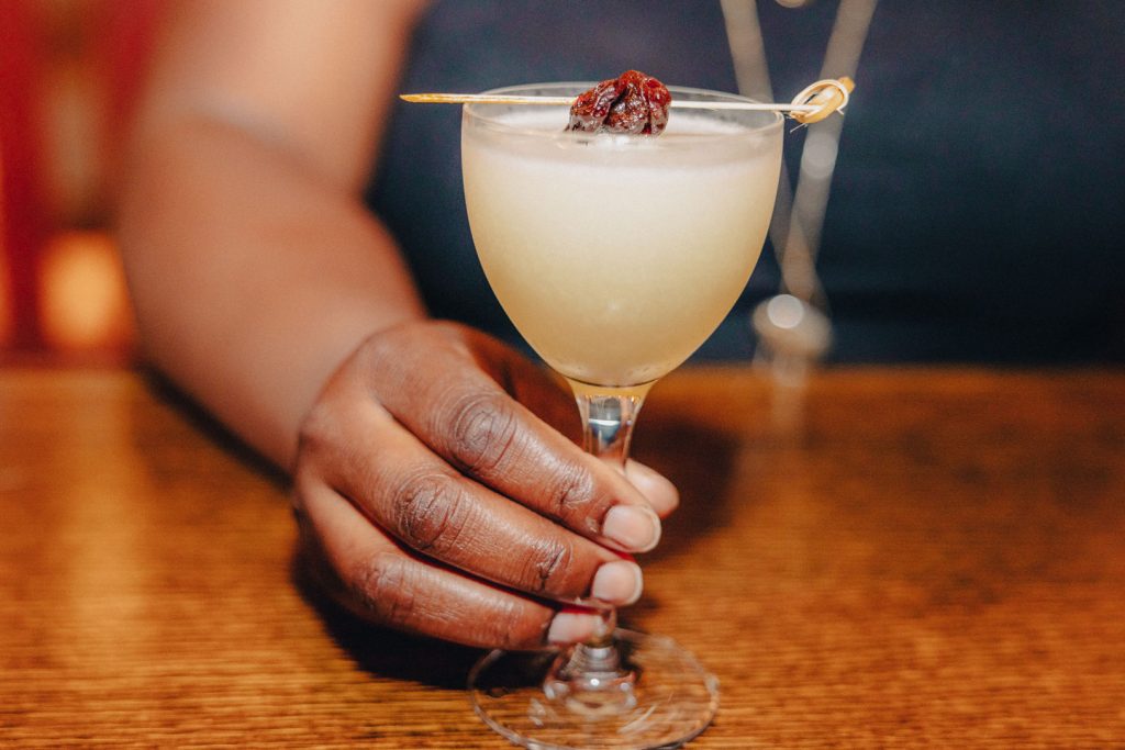 A person holding a Japanese cocktail.