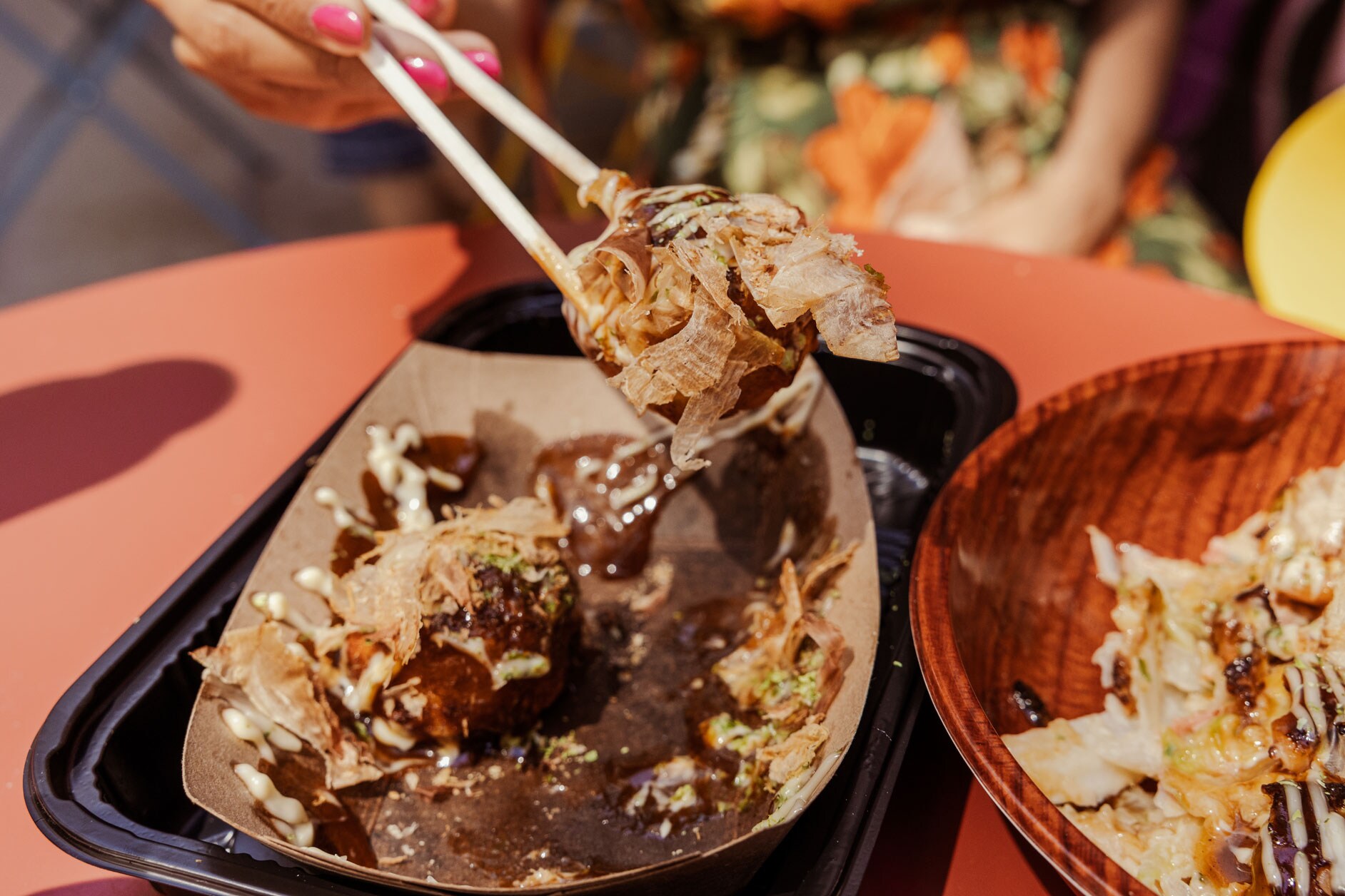 A set of chopsticks holding delicious Japanese food.