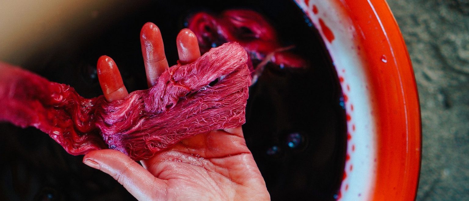 A person holding dyed threads.