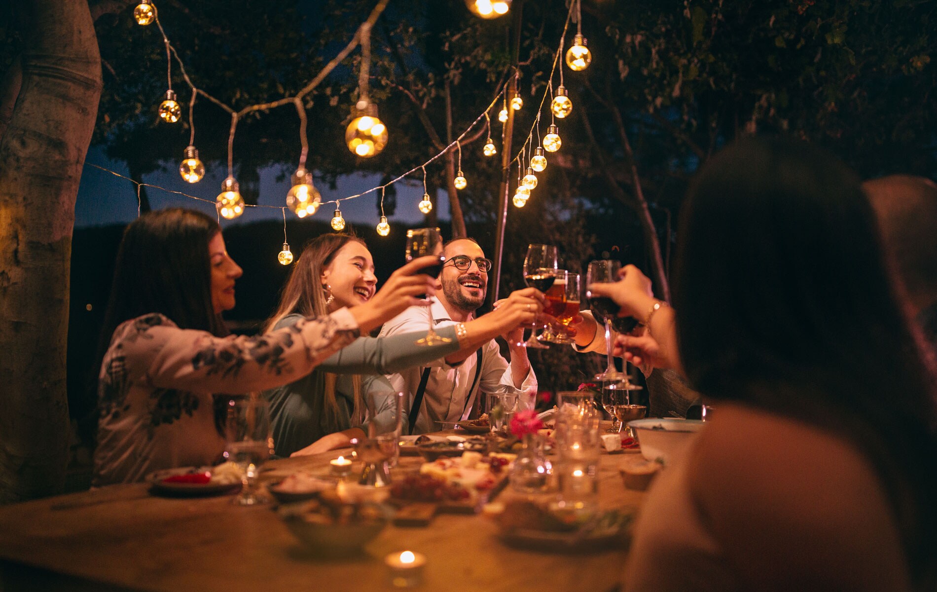 A group of people socializing at a dinner table.