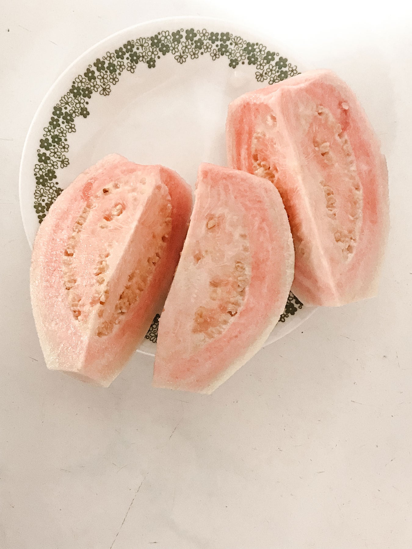A small, delicate plate holding three slices of fruit.