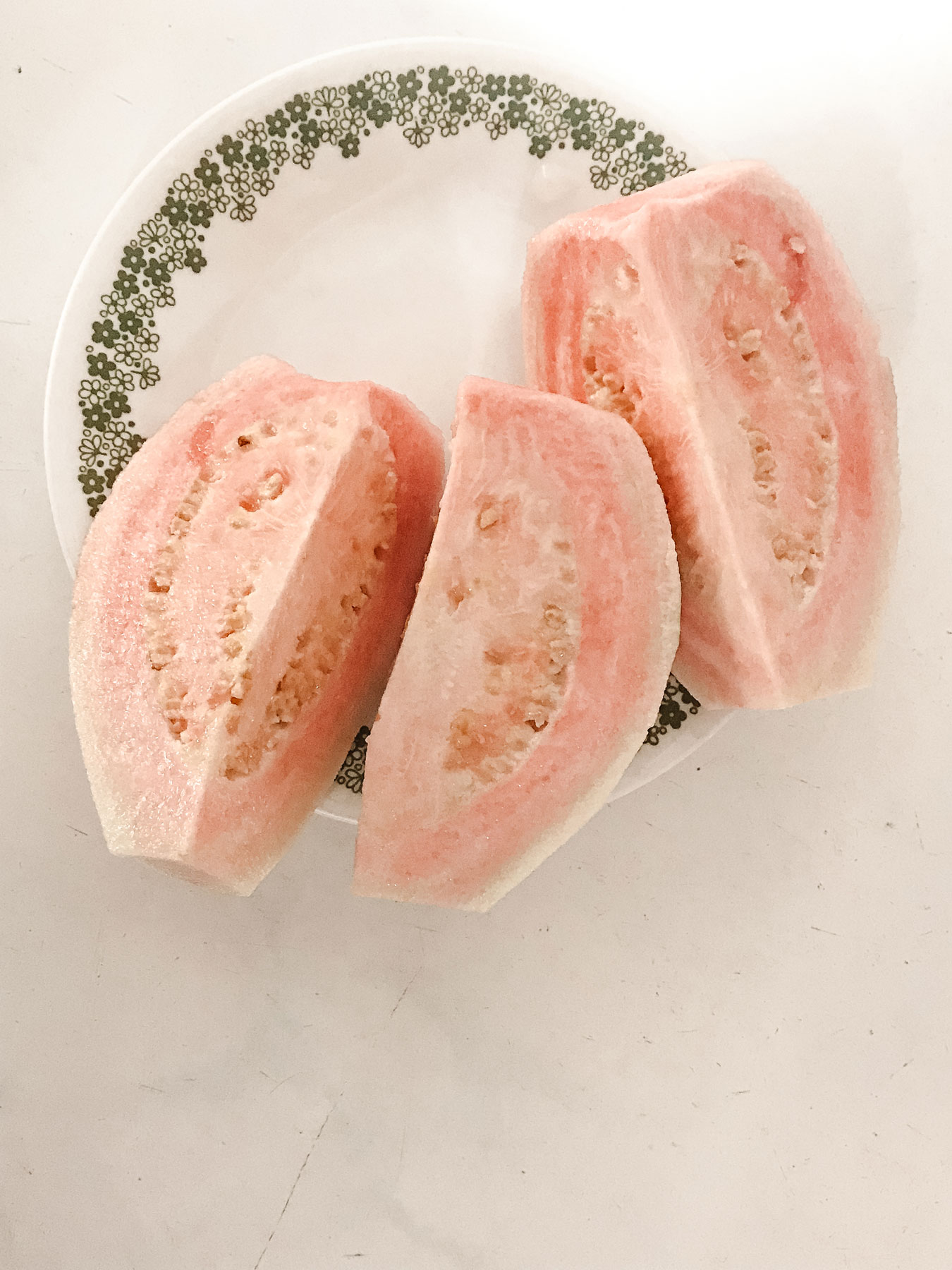 A small, delicate plate holding three slices of fruit.