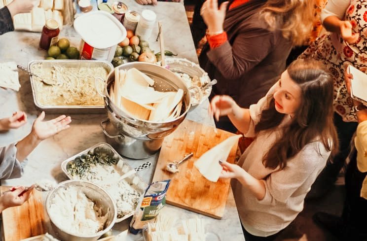 A large family working together over a kitchen counter.