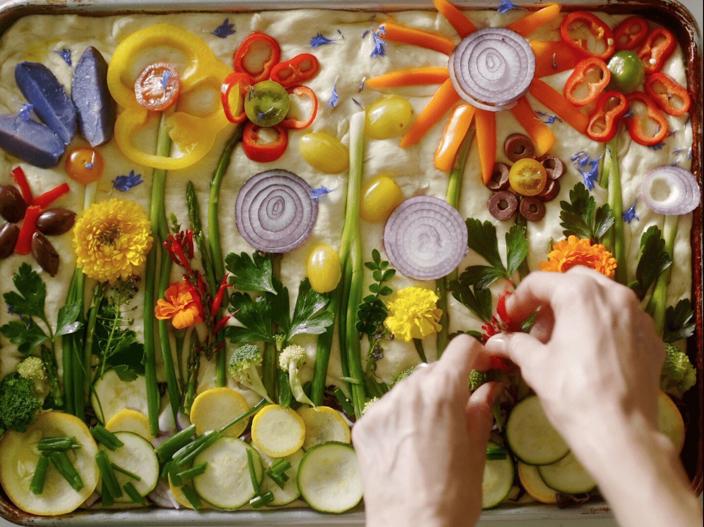Loria Stern pressing edible flowers into focaccia bread.
