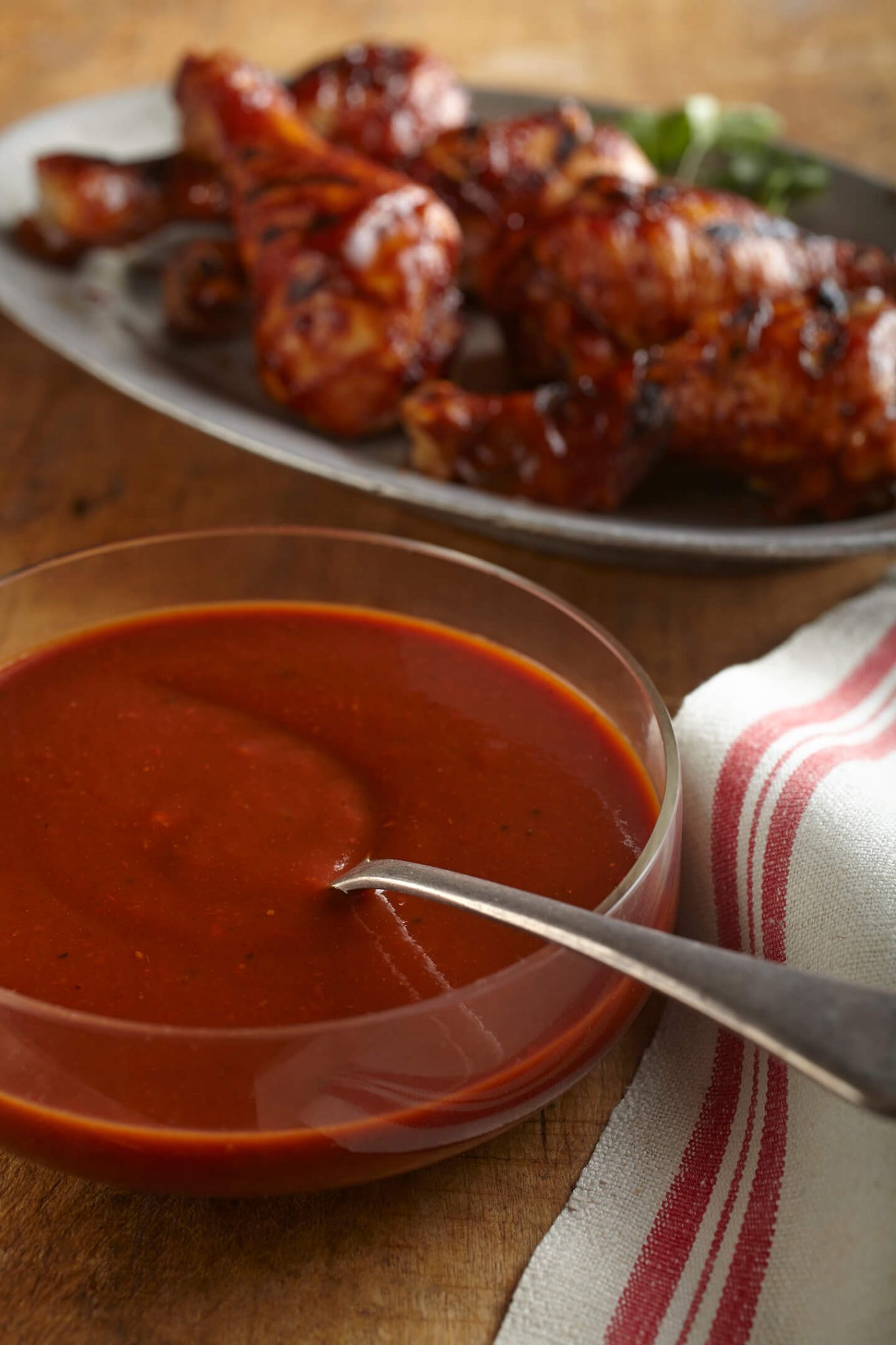 A small glass bowl filled with a homemade sauce for chicken wings.