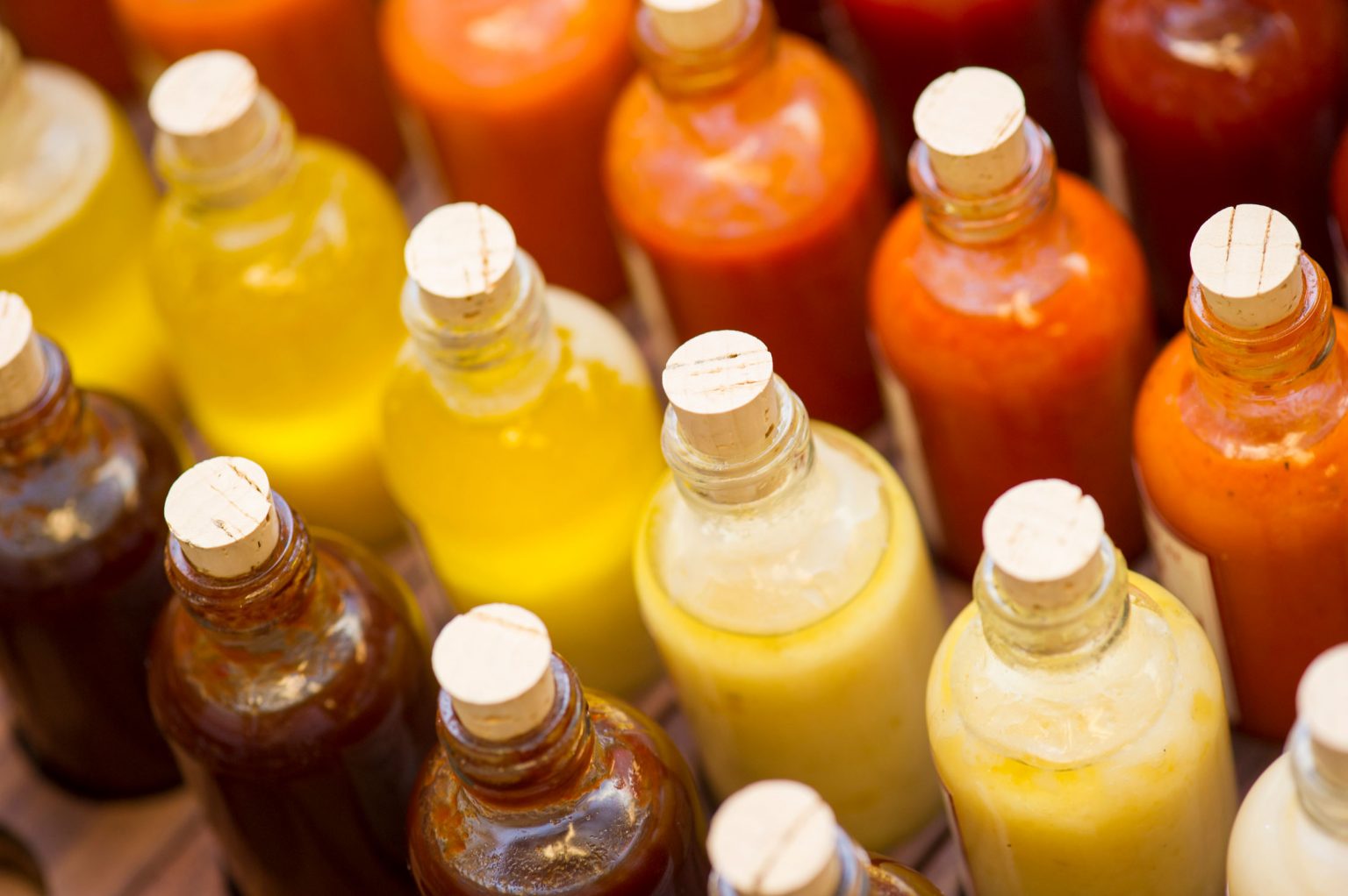 A variety of bottled sauces in a range of warm colors.