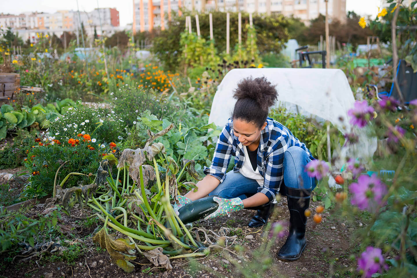 A young woman happily tending to her garden.